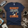 Sorry I'm Late I Didn't Want To Come quote in orange and white text on a navy blue t-shirt. Features