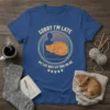 Sorry I'm Late My Cat Was Sitting On Me text on a blue t-shirt with a graphic of a person