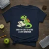Sorry My Crested Gecko Ate My Homework t-shirt design featuring a cute green gecko with a backpack eating papers
