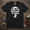 Sorry This Mustache Is Taken text with a mustache graphic and engagement ring box on a black t-shirt