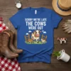 Sorry We're Late The Cows Were Out text with cartoon cow and calves escaping fence graphic on blue t-shirt