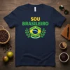 Navy t-shirt with "Sou Brasileiro" in yellow and green text, featuring the Brazilian flag emblem and "Ordem e Progresso" motto