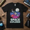 SPACE EXPLORER text with a retro sunset gradient, satellite, moon, and Saturn on a black t-shirt design
