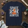 Space Rock Hunter t-shirt design with an astronaut mining on an asteroid, featuring white text and orange accents