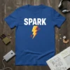 Blue t-shirt with the word SPARK in white text above a yellow and orange lightning bolt graphic, symbolizing energy and