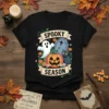 Spooky Season t-shirt design with ghost, jack-o-lantern pumpkin, black cat, and tombstone graphic