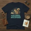 Squirrel Whisperer T-Shirt featuring a cute squirrel holding an acorn and the text "Squirrel Whisperer" in a playful font