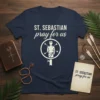 St. Sebastian Pray For Us quote and iconic graphic on a navy t-shirt, with arrows piercing a figure