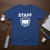 Blue t-shirt with white "STAFF" text and a shield graphic containing two teeth, designed for dental professionals