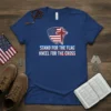 T-shirt with "Stand For The Flag Kneel For The Cross" text, featuring an American flag shield and a distressed cross