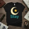 Black t-shirt with a cream crescent moon and yellow star graphic above the word "Stay" in teal text