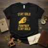 Black t-shirt with yellow text "STAY GOLD PONYBOY STAY GOLD" and a hand holding a coin graphic