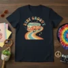 Stay Groovy text above a retro orange VW van driving on a rainbow road, vintage hippie t-shirt design