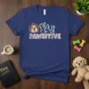 Stay PAWSITIVE quote with cute dog face graphic on a navy blue t-shirt