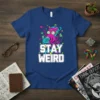 Stay Weird t-shirt design with a pink octopus wearing glasses, reading a book titled "Imagine a Quarantine Space Suit", with