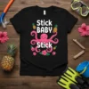 Black t-shirt with "Stick BABY Stick" text, a pink octopus, pineapples, and hibiscus flowers