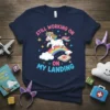 Navy t-shirt with a unicorn on a rainbow saying "STILL WORKING ON MY LANDING" with a target