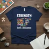 Navy t-shirt with white text "STRENGTH HOPE & RESILIENCE" and a silhouette figure surrounded by colorful awareness ribbons