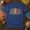 Sugar Skull Design T-Shirt featuring three colorful calaveras, marigolds, and candles, evoking Day of the Dead imagery