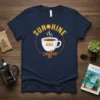 Navy t-shirt with "SUNSHINE AND coffee" text and a steaming coffee cup graphic, featuring a smiling sun