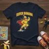 Super Banana T-Shirt featuring a muscular cartoon banana character in a superhero costume with a red cape and yellow suit