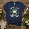 Support Your Local Flower Farmer text with a wheelbarrow full of flowers graphic on a navy blue t-shirt