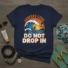 Surfers Code Do Not Drop In t-shirt design featuring a surfer on a wave with a sunset and palm trees