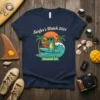 Surfer's Watch 2024 Emerald Isle t-shirt design with a cool alligator on a surfboard, palm trees, and ocean waves
