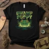 Swamp Puppy t-shirt design featuring a camouflage text and a cute alligator face in water with grass