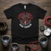 Black t-shirt with red and white "Sweat Today Shine Tomorrow" text and a winged torch graphic, fitness motivation design