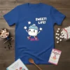 SWEET! LIFE! text with a cute cartoon marshmallow character juggling marshmallows, on a blue t-shirt