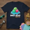 SWEET RELIEF text above melting ice cream scoops on a dark t-shirt, with a wooden spoon and sprinkles graphic