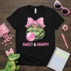Sweet & Snappy t-shirt design with a green alligator wearing pink glasses and a bow, blowing pink bubblegum
