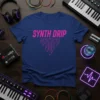 Blue t-shirt with "Synth Drip" in pink neon font and a circuit board design, surrounded by music equipment