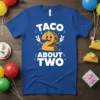 Taco About Two birthday t-shirt design with a cartoon taco character in the shape of the number two, holding peace