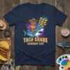 Taco Shark Cowboy Cat T-Shirt featuring a cat in a cowboy hat riding a shark surrounded by tacos