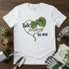 White t-shirt with black and green text "Talk planty to me" inside a heart made of vines and Monstera leaves