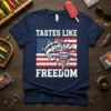 Tastes Like Freedom t-shirt with a bass fish and ice cream cone on an American flag design