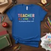 TEACHER in progress please wait quote on a blue t-shirt with school supply graphics and loading bar