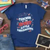Teacher of the Cutest Little Firecrackers text design with patriotic fireworks and rockets on a navy blue t-shirt