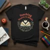 Black t-shirt with "Teaching Hearts & Minds" text above an open book graphic with a heart and educational icons
