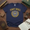 Navy blue t-shirt with yellow 'Temet Nosce' text above a circular maze containing an eye, framed by laurel leaves