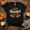 Black t-shirt with "Thankful Est Fall 2023" text and pumpkin graphics, perfect for Thanksgiving