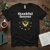 Thankful forever quote t-shirt with hands holding a plant graphic, surrounded by nature elements like sun and leaves