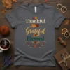 Thankful Grateful Blessed text with autumn leaves and berries graphic on a grey t-shirt