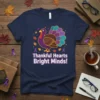 Navy t-shirt with "Thankful Hearts Bright Minds!" text and a cartoon turkey with brain-patterned tail feathers