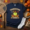Thanksgiving Tennis t-shirt design featuring a smiling tennis ball wearing a pilgrim hat and holding a racket