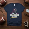 Navy blue t-shirt with "THAT'S MY GRANDSON OUT THERE" text and a football player graphic, design for proud grandparents
