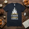 Dark navy t-shirt featuring the phrase "THAT'S WHAT I DO I BAKE AND KNOW THINGS" with a castle-like cake graphic