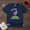 The Amazing Dancing Poodle T-Shirt featuring a cartoon purple poodle in a pink tutu, dancing on grass. Text reads "THE